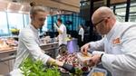 Chefs preparing dishes in a busy kitchen.