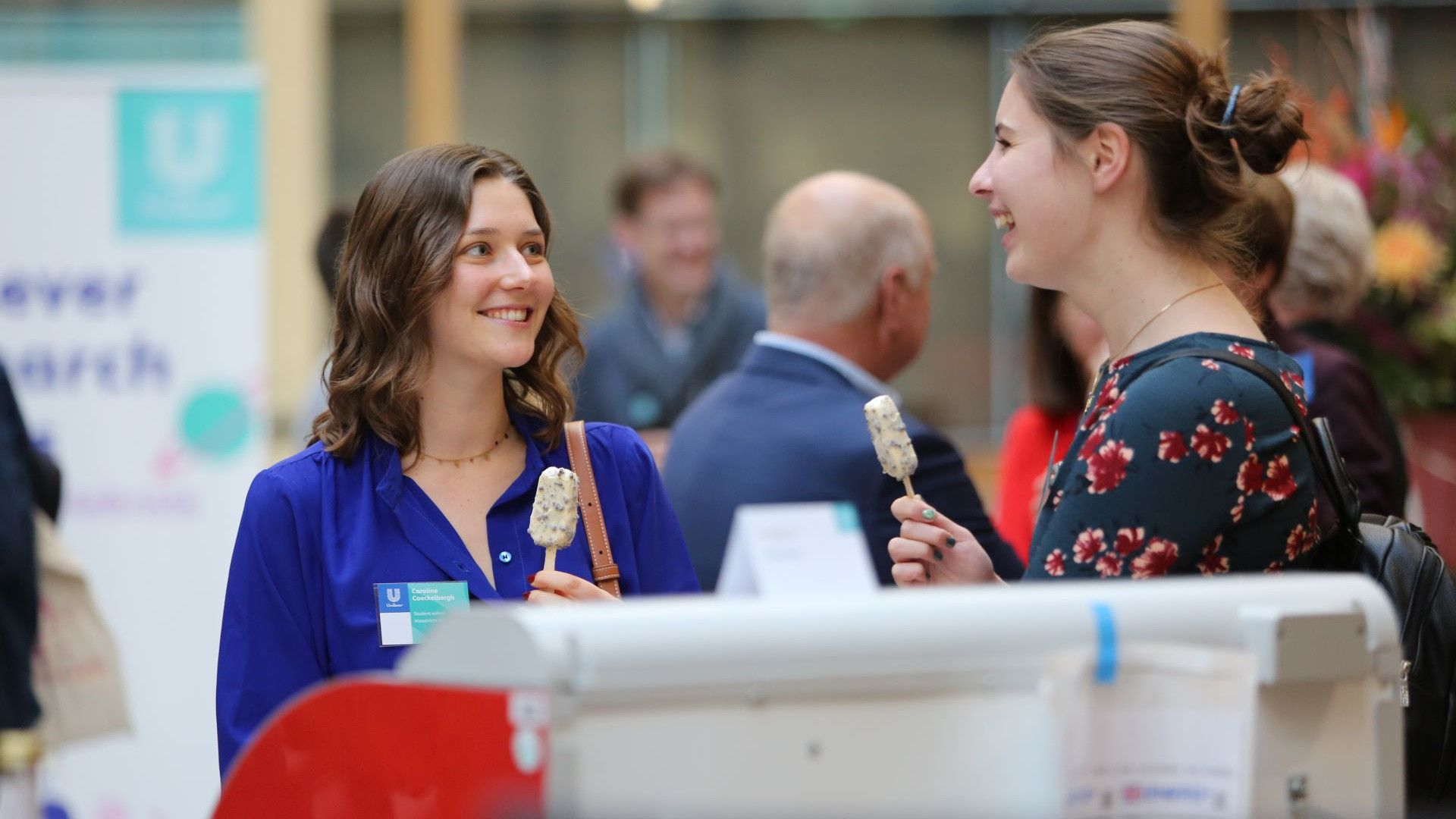 Two student winners eating ice cream during the poster presentation lunch for the Research Prizes.